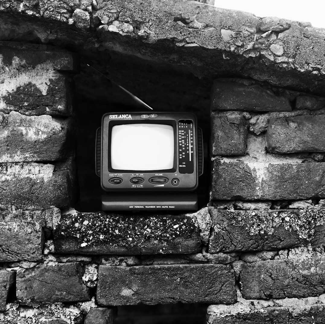 Vieux téléviseur à tube cathodique diffusant une image en noir et blanc
